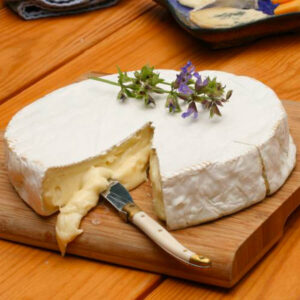 Forma di formaggio Brie su tagliere di legno