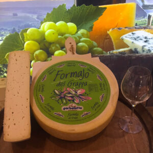 Forma di formaggio Formajo del Grappa su tagliere