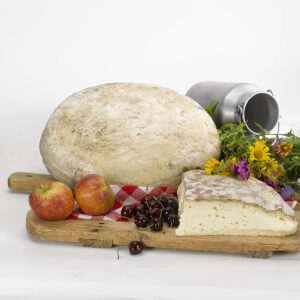 Fetta di formaggio Morlacco del Grappa Riserva su un tagliere con della frutta